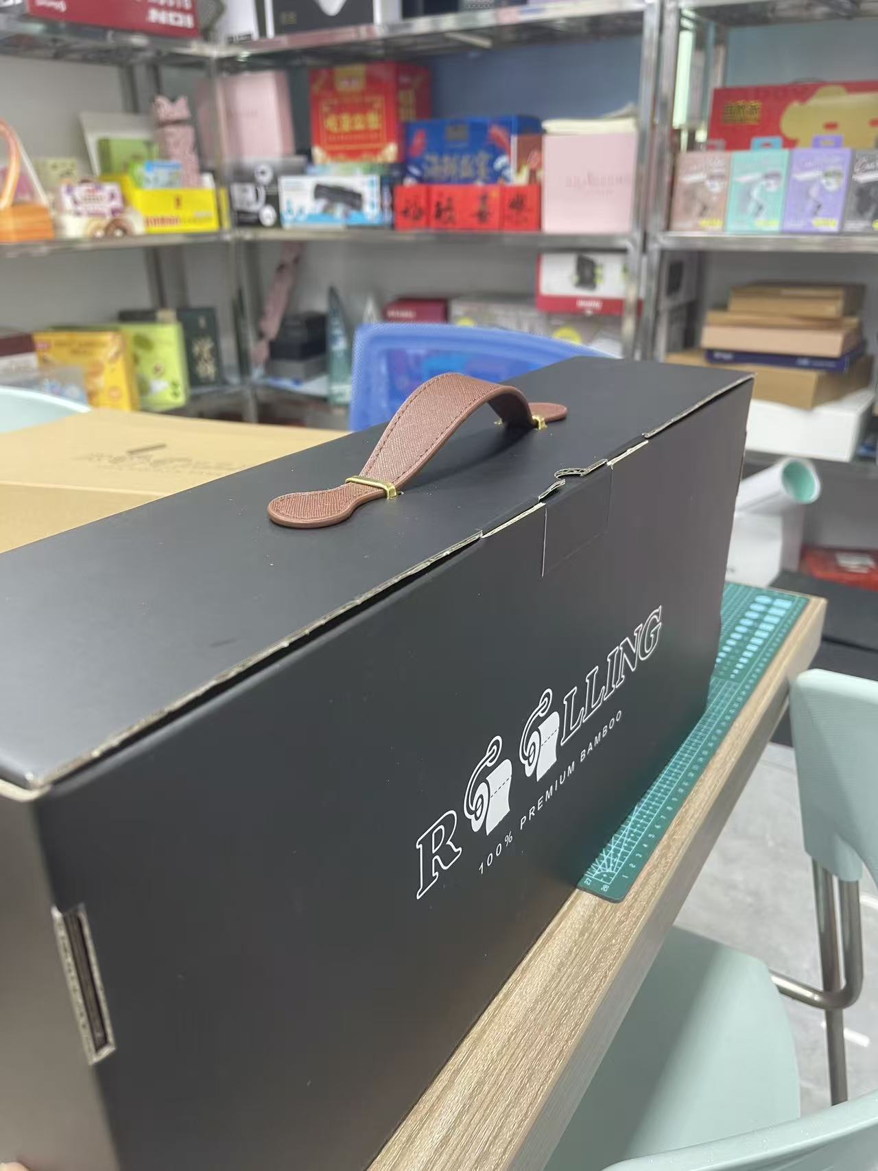 Black corrugated gift mailer with a brown PU carry handle for bamboo toilet paper