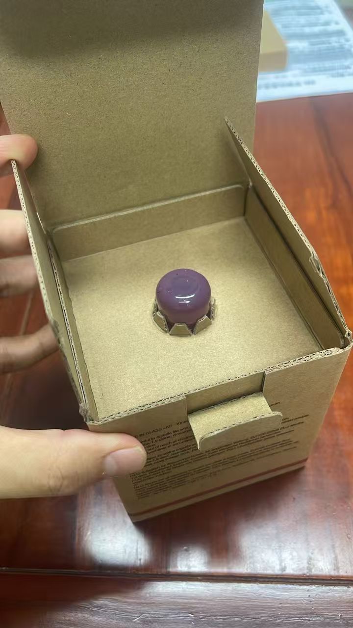 Upper and lower corrugated inserts supporting a glass candle jar inside a carton