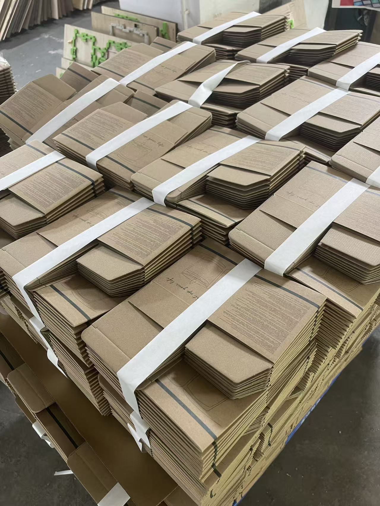 Stacks of printed kraft corrugated candle cartons during production